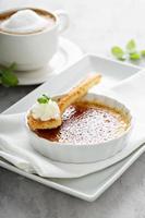 creme brulee efterrätt med en kopp av cappuccino foto