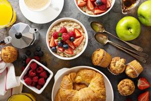 frukost tabell med gröt gröt, croissanter och muffins foto