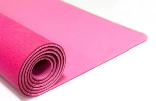 stänga upp rosa yoga matta isolerat på vit bakgrund foto