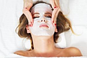 kvinna med ansiktsbehandling mask i skönhet salong foto
