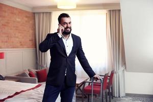 ung affärsman i hotell rum med smartphone foto