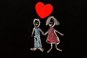 krita teckning man och kvinna med röd hjärta på de svarta tavlan. foto