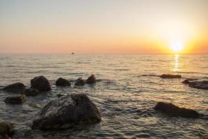 solnedgång över havet bland klipporna foto