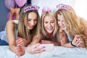 bild presenter Lycklig grupp av vänner använder sig av smartphone foto