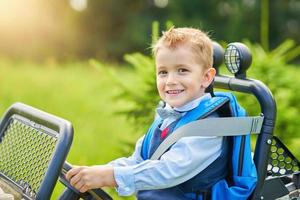 skola pojke körning barn bil med ryggsäck foto