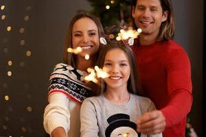 skön familj fira jul och innehav sparklers foto