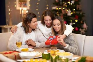 skön familj med presenterar delning presenterar under jul middag foto