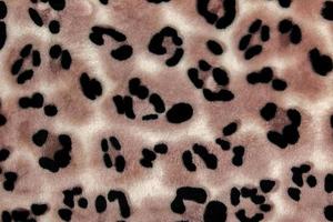 närbild mönster av skinna tyg med leopard mönster. brun-beige och svart randig upprepa på de yta av päls kläder, abstrakt textur bakgrund. foto
