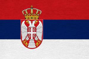 serbia flagga på en texturerad bakgrund. begrepp collage. foto