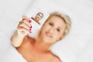 vuxen skön kvinna tar omedelbar Foto i säng