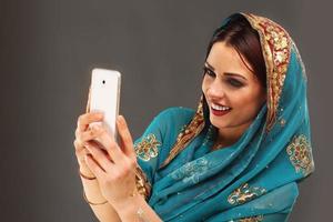 arabicum kvinna använder sig av smartphone foto
