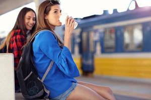 flicka vänner turister på järnväg plattform foto