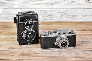 gammal kamera med två linser och retro kamera på en trä- bakgrund foto