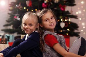 Lycklig barn Framställ i främre av jul träd foto