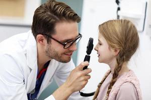 barn manlig optiker undersöker syn av liten flicka foto