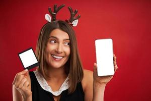 kvinna i jul humör jämförande omedelbar bilder till smartphone kamera över röd foto