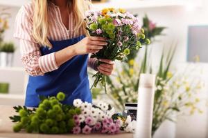 kvinna blomsterhandlare arbetssätt i blomma affär foto