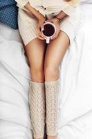 kvinna ben och kaffe på säng foto