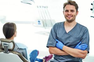 manlig tandläkare och kvinna i tandläkare kontor foto