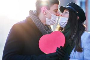 Lycklig par fira valentines dag i masker under covid-19 pandemi foto