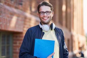 manlig studerande i de campus studerar utomhus foto