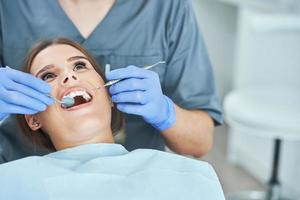 manlig tandläkare och kvinna i tandläkare kontor foto