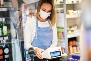 affär assistent arbetssätt i medicinsk mask foto