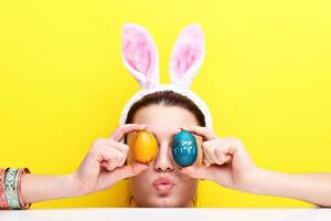 Lycklig ung kvinna bär kanin öron och har påsk ägg foto