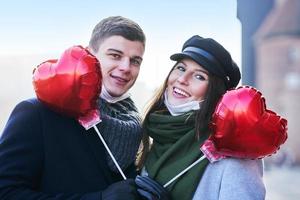 Lycklig par fira valentines dag i masker under covid-19 pandemi foto