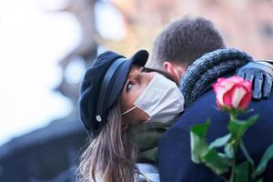 Lycklig par fira valentines dag i masker under covid-19 pandemi foto