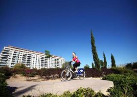 ung kvinna cykling i de parkera foto