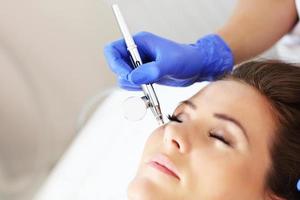 kvinna har ansiktsbehandling behandling i skönhet salong foto