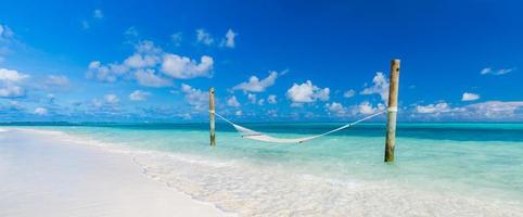 lyx strand. lyx resa bakgrund. sommar semester eller Semester begrepp på tropisk strand, vit sand och ett Fantastisk gunga eller hängmatta över blå hav med horisontell se. lyxig Semester tillflykt foto