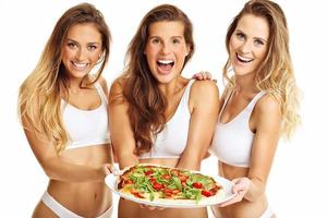 Lycklig passa kvinnor Framställ med pizza foto