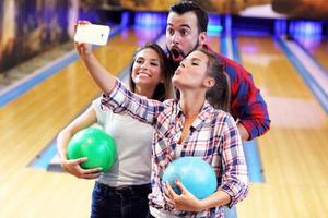 vänner spelar bowling foto