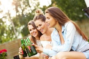 Lycklig grupp av vänner dricka öl utomhus foto
