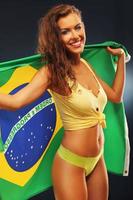 Lycklig brasiliansk fläkt glädjande med flagga foto
