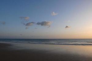 ensam, trångt strand med lugna hav och små vågor foto