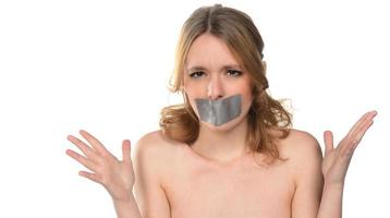 rädd ung kvinna med tejp över henne mun. foto