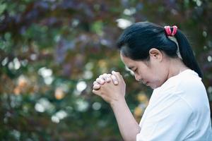 bön person hand i svart bakgrund. kristen katolik kvinna är bön- till Gud i mörk på kyrka. flicka tro och tro i Jesus Kristus. christ religion och kristendomen dyrkan eller be begrepp. foto