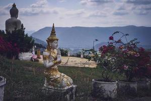 skön vit stuck buddha staty inskriven på de sluttning den är en plats av meditation kallad wat sutesuan, nam nao distrikt, thailand. foto
