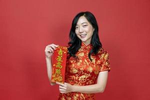 asiatisk kvinna innehav röd förmögenhet välsignelse kinesisk ord som betyder till vara välsignad förbi en tur- stjärna isolerat på röd bakgrund för kinesisk ny år firande begrepp foto