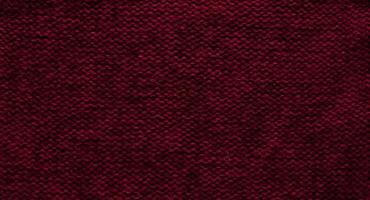 textur av slät stickat Tröja med mönster. handgjort stickning ull eller bomull tyg textur. bakgrund av stor sticka mönster med stickning nål eller virka. Färg av de år 2023 - viva magenta foto