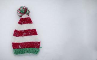 stickat jul hatt på en vit bakgrund. rolig jul hatt på snö bakgrund. foto