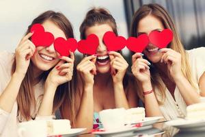 tre flick innehav hjärtan i Kafé foto
