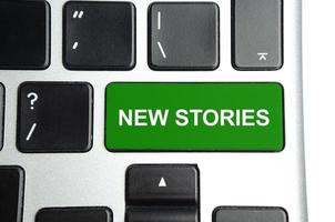 ny berättelser ord på grön tangentbord knapp foto