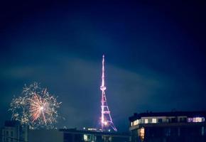 skön natt landskap med honnör och fyrverkeri förbi kaptal TV torn på mtantsminda kulle i tbilisi stad, georgien foto