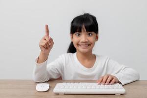 utbildning, skola, och imaginär skärm begrepp - asiatisk liten flicka pekande i de luft eller imaginär skärm foto