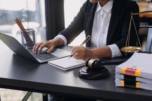 lag böcker och skalor av rättvisa på skrivbord i bibliotek av lag fast. juridik Rättslig utbildning begrepp. foto