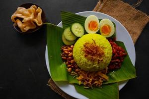 nasi kuning eller gul ris eller tumör ris är traditionell mat från Asien, tillverkad ris kokta med gurkmeja, kokos mjölk r foto